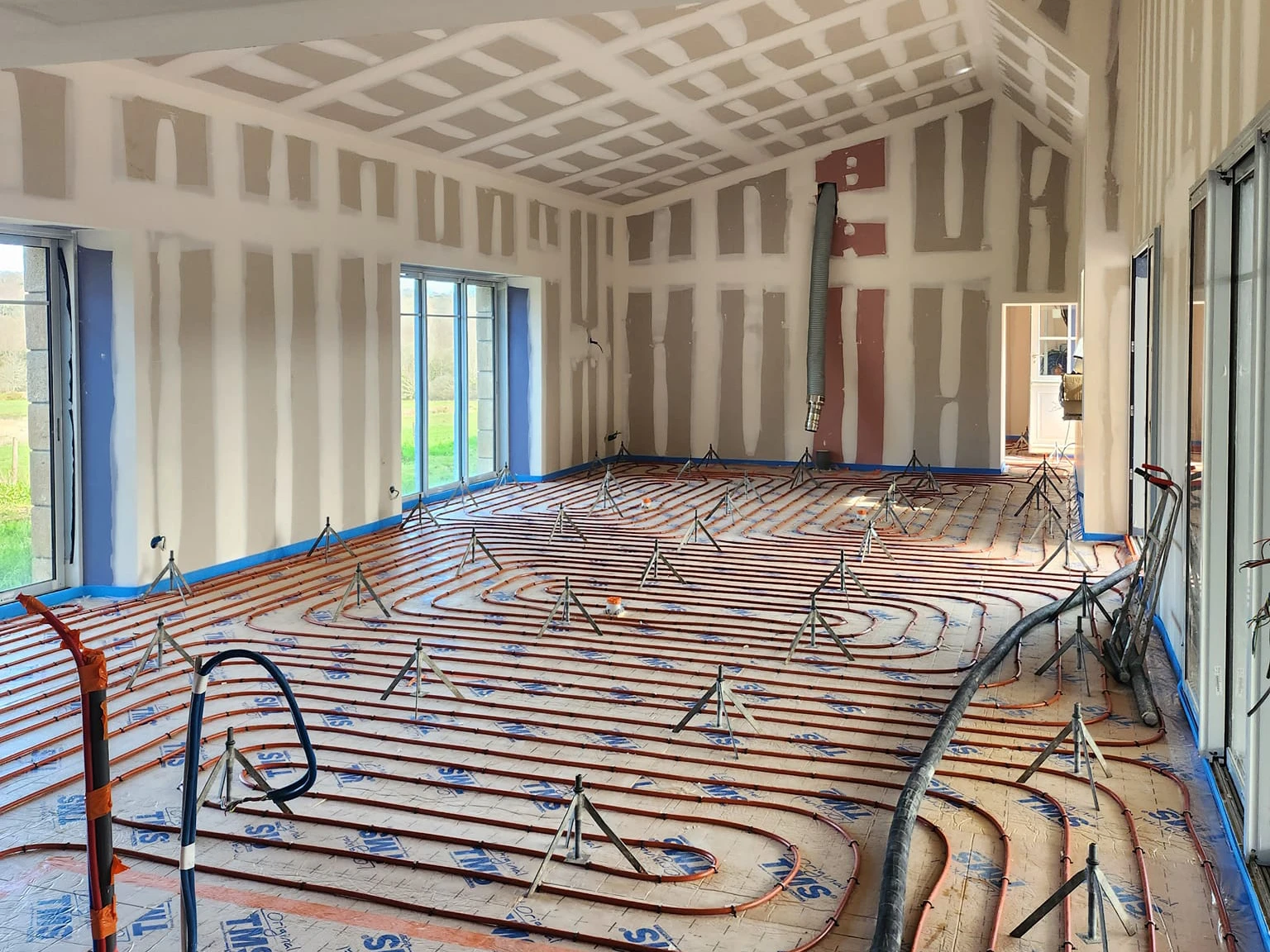 Chantier de carrelage en cours, surface partiellement carrelée avec carreaux de mosaïque bleu turquoise disposés en grille régulière