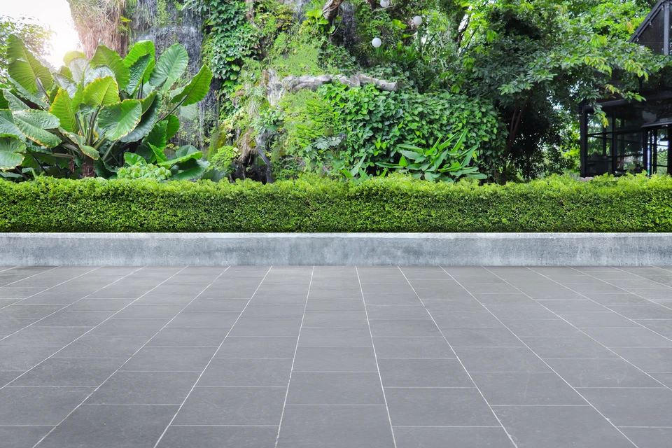 Ouvrier en tenue de protection installant un dallage extérieur sur lit de sable